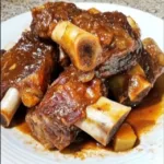 "Close-up of perfectly cooked beef back ribs glazed with rich BBQ sauce, showcasing the tender, juicy meat.