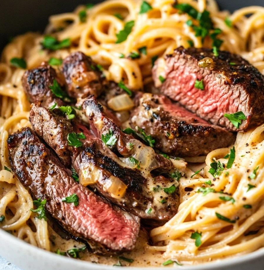 One-pot creamy spicy garlic butter steak and pasta dish topped with herbs